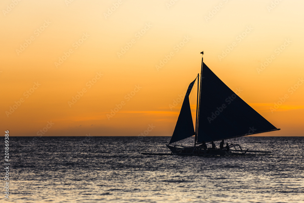 One outrigger sailboat on the horizon