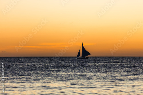 One outrigger sailboat on the horizon