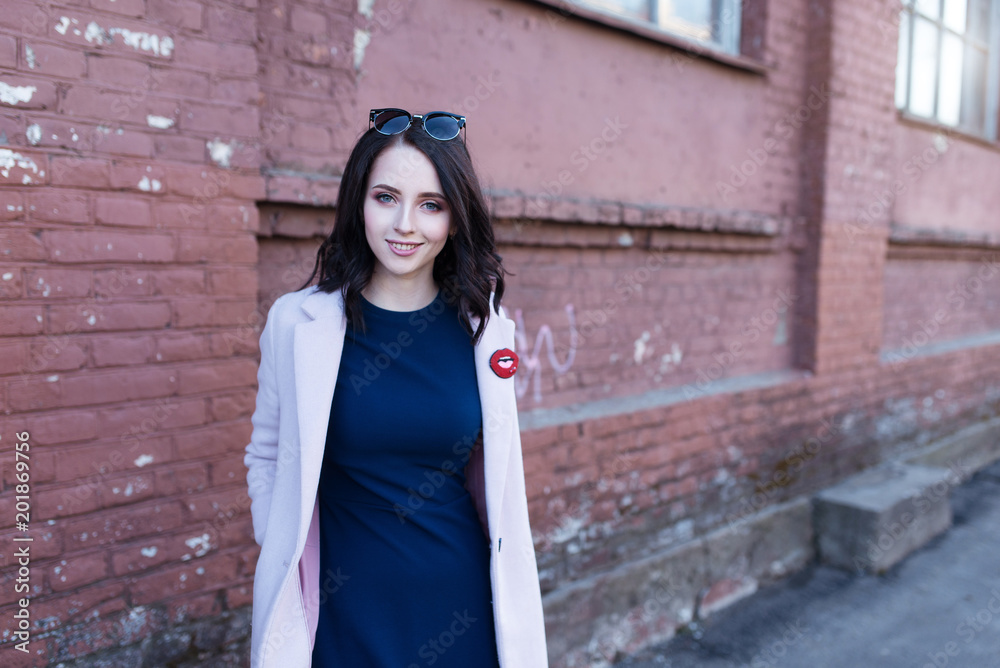 Portrait of young beautiful smiling girl with brown hair in the city.