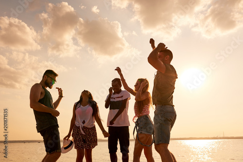 Fotografie Positive euphoric young multiethnic friends in comfortable casual clothing danci