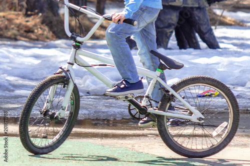 boy in blue jeans on a white bicycle