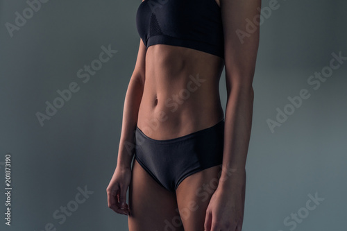 Portrait of a female sporty sexy figure in a black swimsuit, close-up