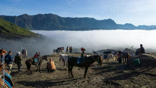 4K Time lapse of Bromo horsemen and foggy morning over mountain range at Mount Bromo, Semeru, Tengger National Park, Indonesia.