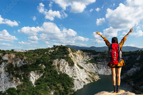 Fototapeta Naklejka Na Ścianę i Meble -  Hiker woman cheering successful woman backpacker open arms on mountain peak