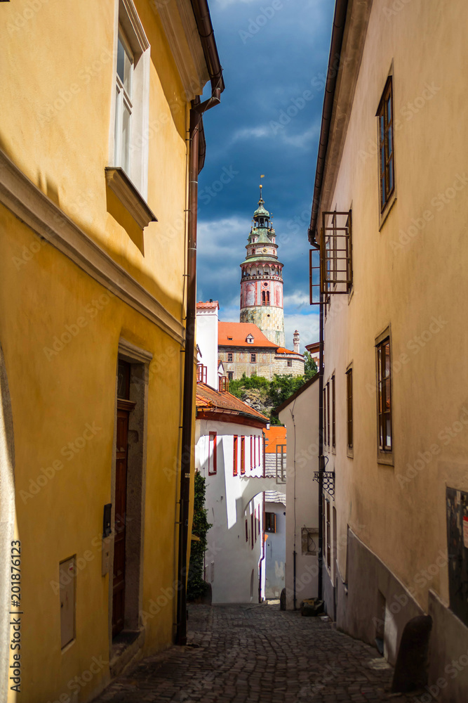 Narrow street in Cesky Krumlov and view of castle tower, Czech republic