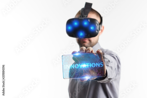 Business, Technology, Internet and network concept. Young businessman working in virtual reality glasses sees the inscription: Innovations