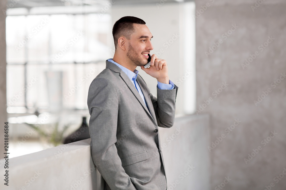 business people, technology and corporate concept - happy smiling businessman calling on smartphone at office business people, technology and corporate concept - happy smiling businessman calling on smartphone at office