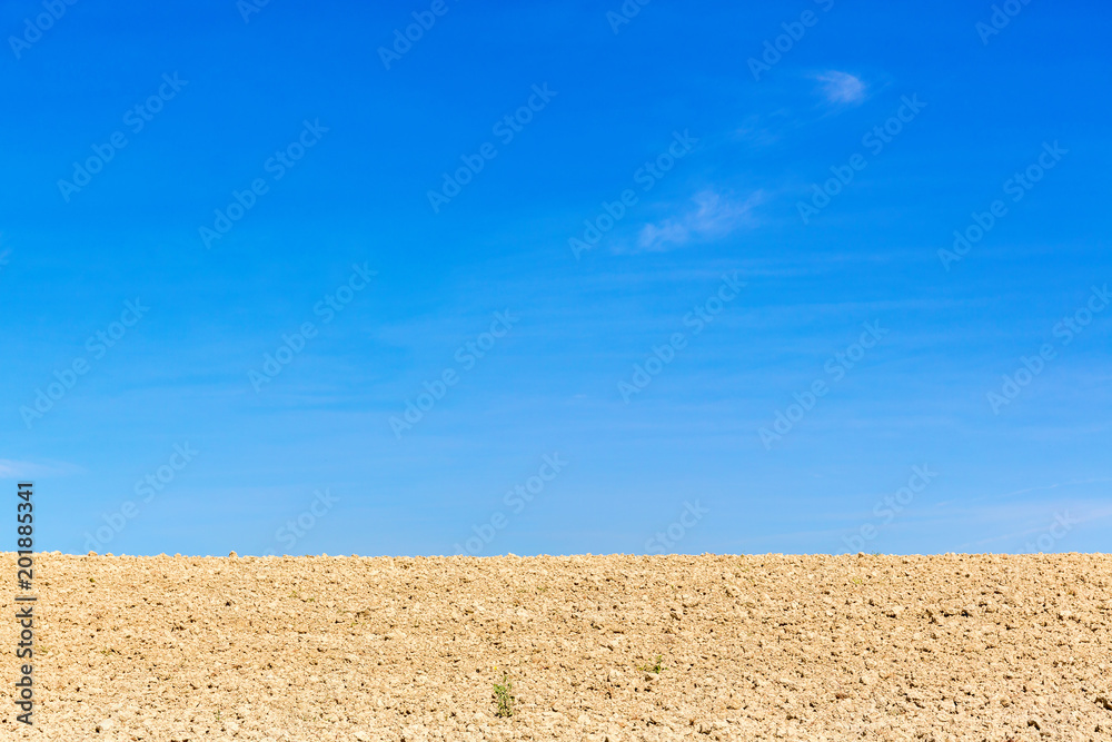 Soil field against a blue sky
