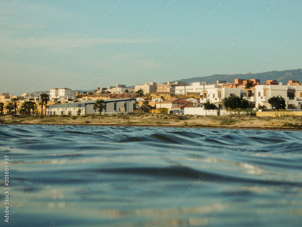 blue seascape with a tiny village Taria in Spain in the background
