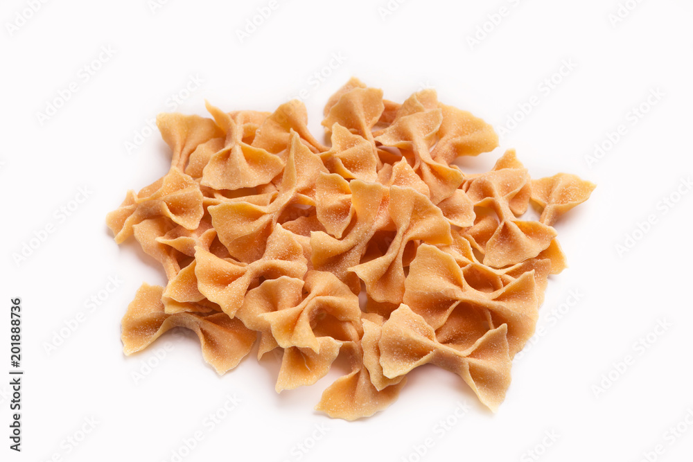 Heap of orange farfalle pasta isolated on white Heap of orange farfalle pasta isolated on white