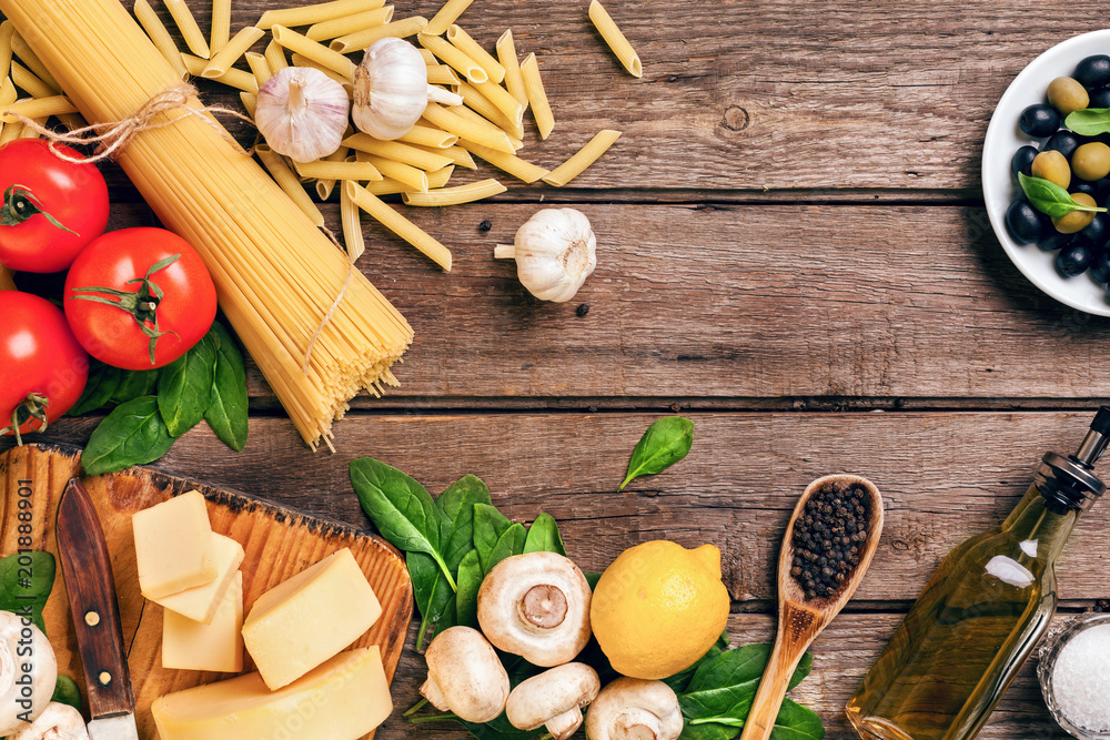 Ingredients for spaghetti with basil, tomatoes, cheese on wooden background, top view, place for text Ingredients for spaghetti with basil, tomatoes, cheese on wooden background, top view, place for text