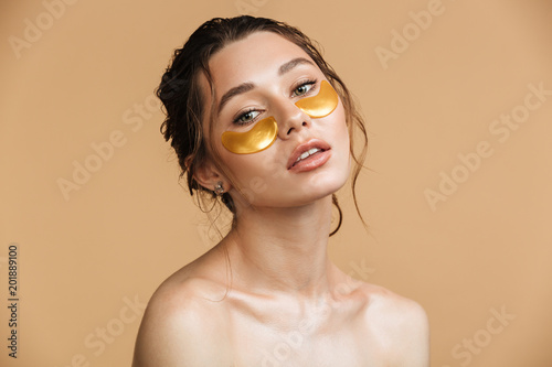 Obraz na plátne Beautiful gentle woman take care of her skin with under eye patches