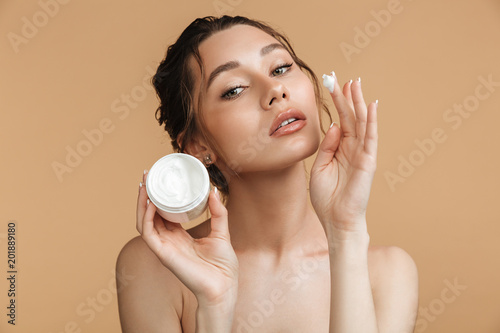 Beautiful gentle woman holding cream take care of her skin.