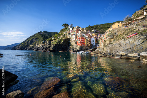 Riomaggiore fisherman village at sunset. Riomaggiore is one of five famous colorful villages of Cinque Terre in Italy, suspended between sea and land on sheer cliffs. Liguria, Italy
