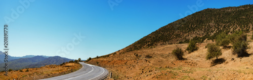 Panoramic landscape with asphalt road and mountains over blue clear sky. Road that leads to the monasteries on the top of Meteora , Greece