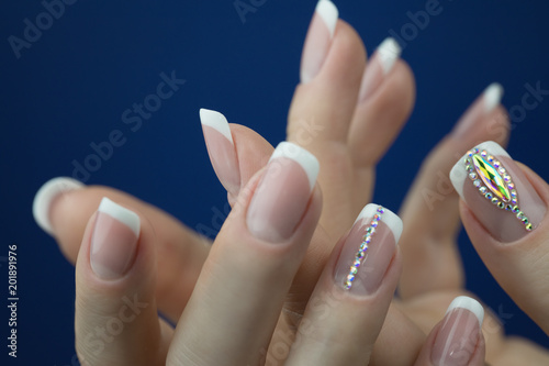Female hands with beautiful french manicure with decotations. photo