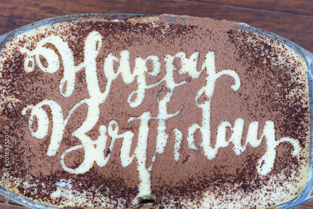 Text Happy Birthday geschrieben mit Kakao auf Kuchen, Herzlichen