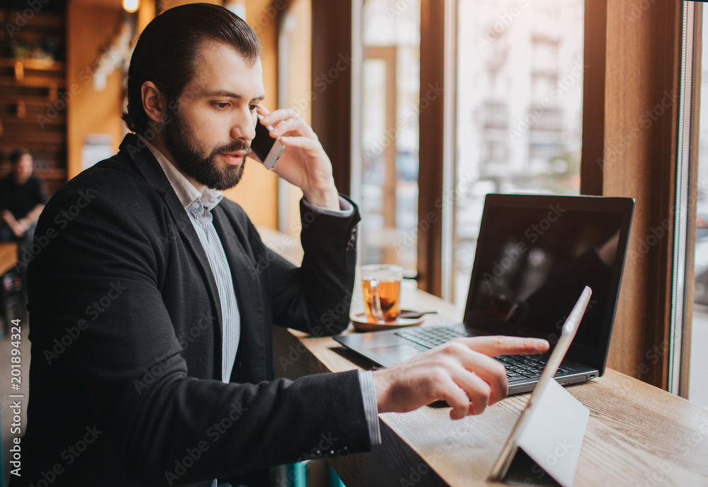 Busy man is in a hurry, he does not have time, he is going to eating and working. Worker eating, drinking coffee, talking on the phone, at the same time. Businessman doing multiple tasks. Multitasking