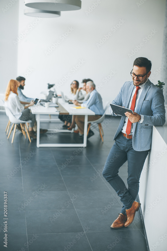 Young businessman with digital tablet in office Young businessman with digital tablet in office