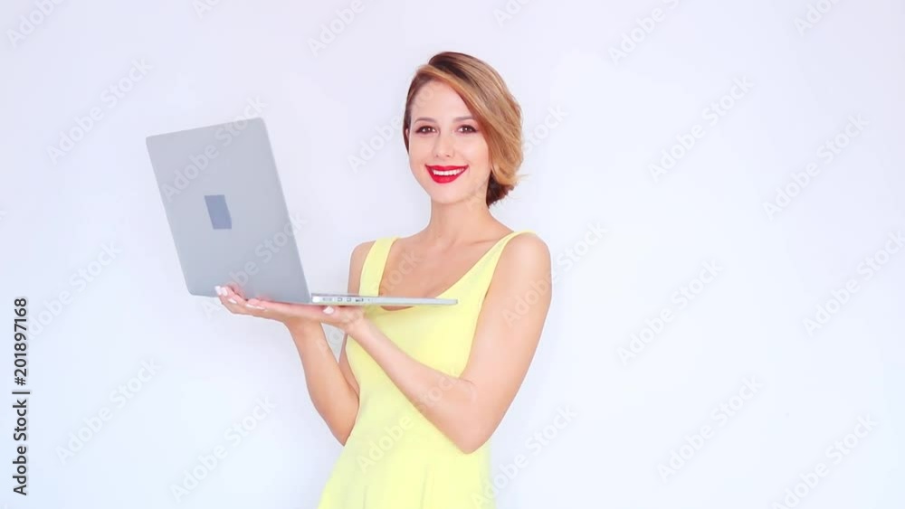 Young redhead girl in yellow dress with laptop computer on white background Young redhead girl in yellow dress with laptop computer on white background