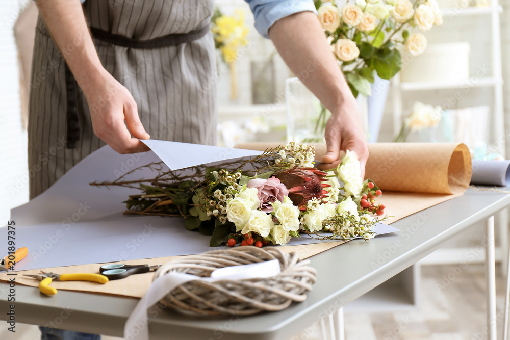 Male florist creating bouquet at workplace Male florist creating bouquet at workplace