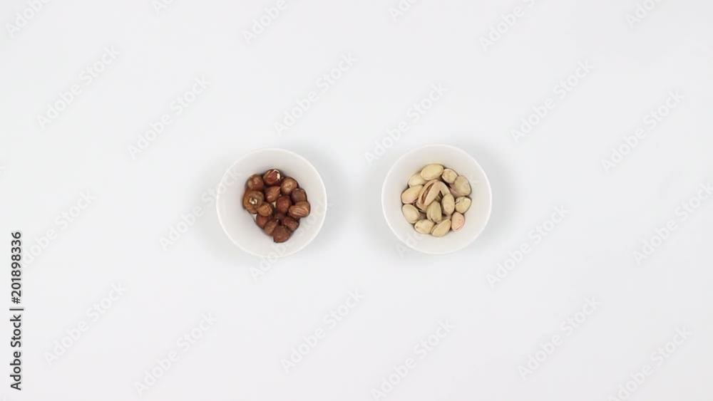 Couple drink beer and eat nuts. Hazelnuts and pistachios. Fast shooting. Top view Couple drink beer and eat nuts. Hazelnuts and pistachios. Fast shooting. Top view