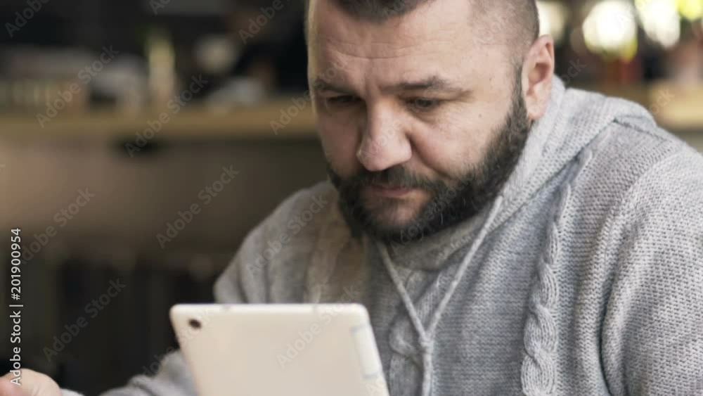 Happy, young man reading news on tablet during meal in cafe
Happy, young man reading news on tablet during meal in cafe