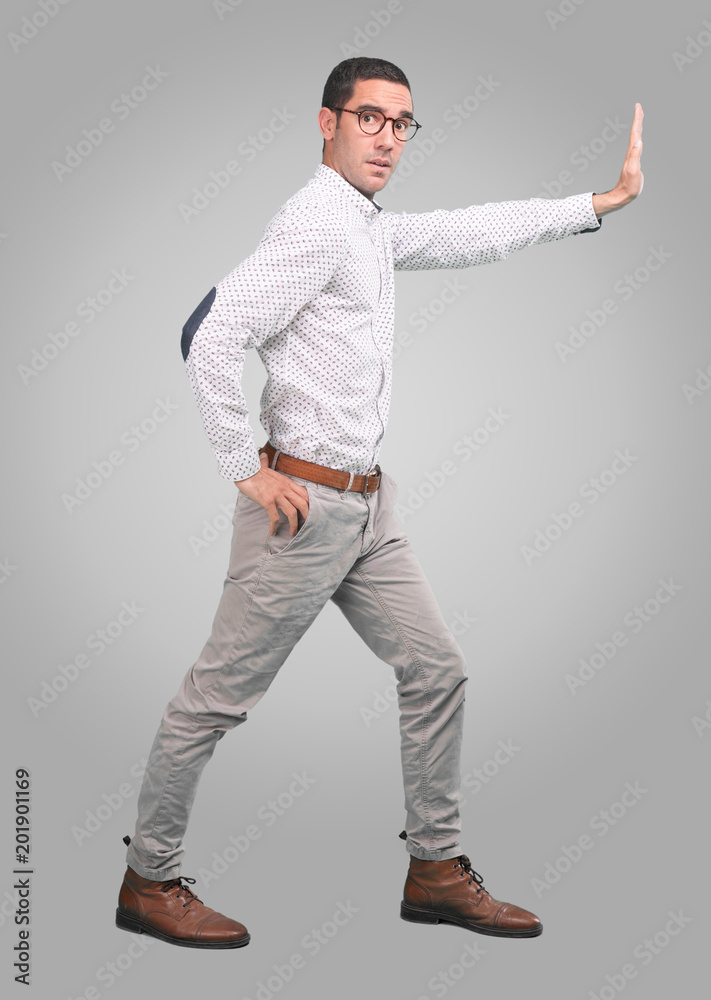 Concerned young man with a gesture of hold - Full body shot Concerned young man with a gesture of hold - Full body shot