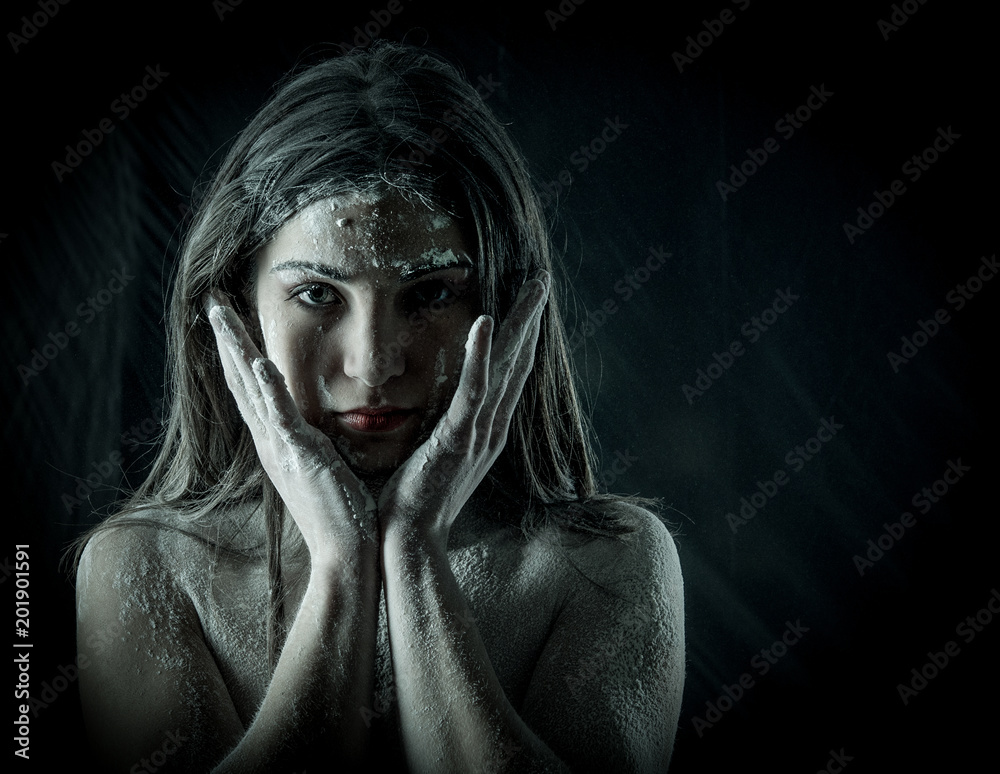 woman with powder in the studio on a black background