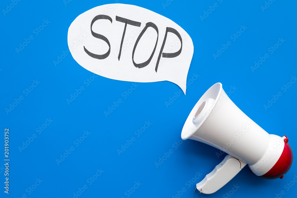 Fototapeta premium Demand to stop concept. Megaphone near cloud with word stop on blue background top view space for text