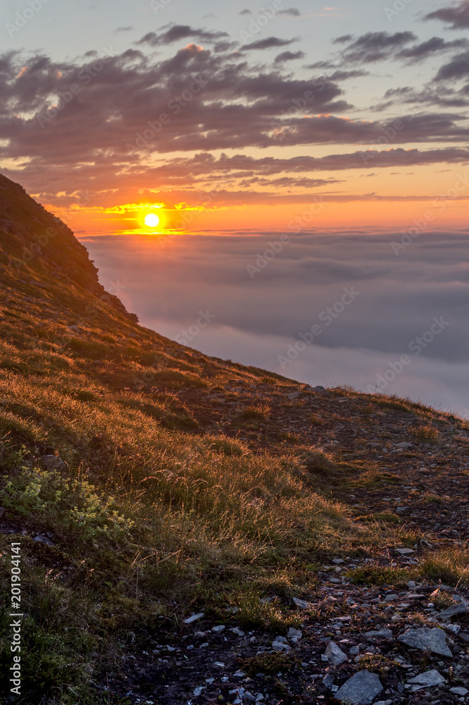 Sunset in the fog on the mountains of Soroya Island, Norway