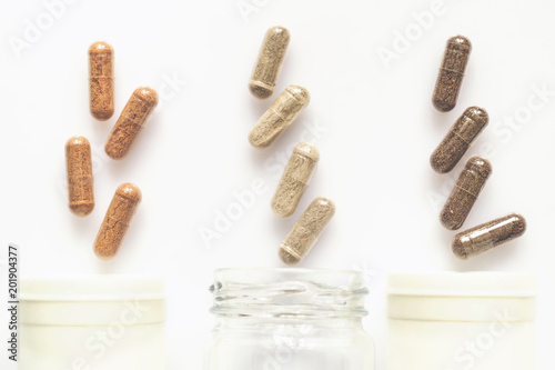 Medicinal capsule spill out of a three plastic bottles