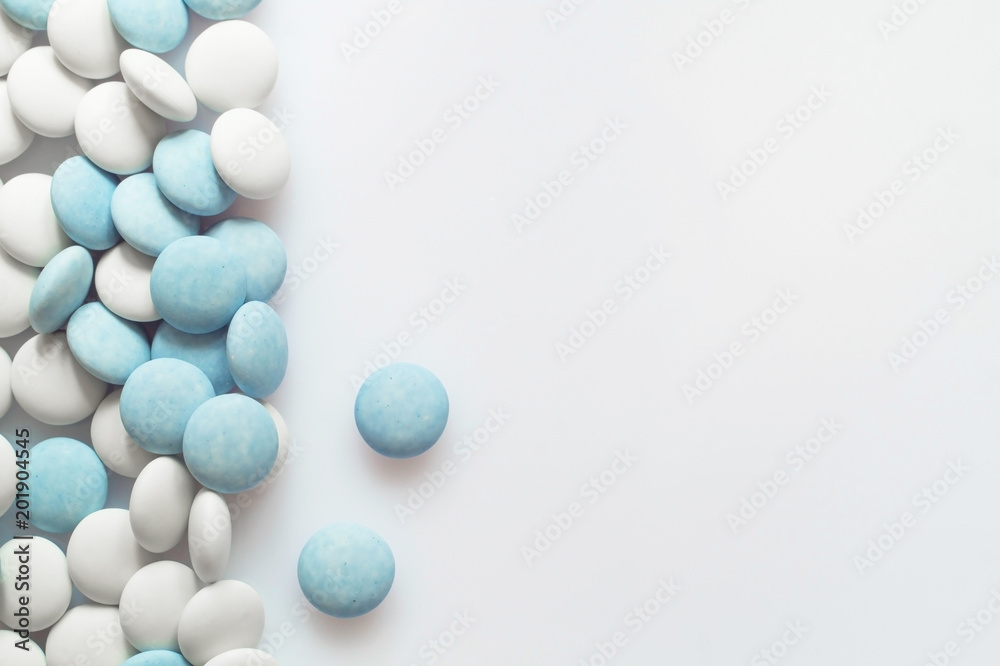 White and blue pills on light surface