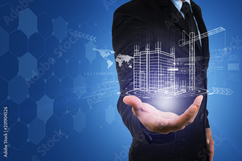 Fototapeta Naklejka Na Ścianę i Meble -  Businessman's hand with building construction design reality virtual technology. Building automation digital wireless control concept.