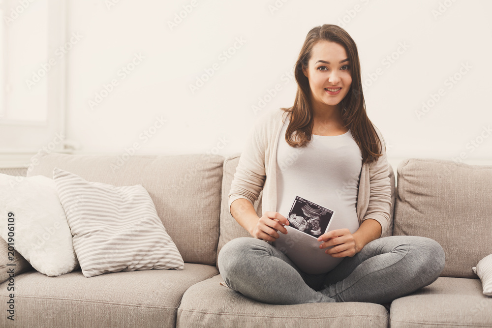 Obraz premium Pregnant woman looking at her baby sonography