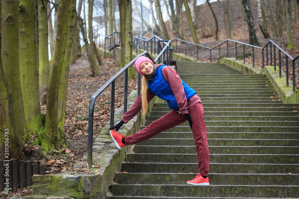 Fototapeta premium Woman wearing sportswear exercising outside during autumn
