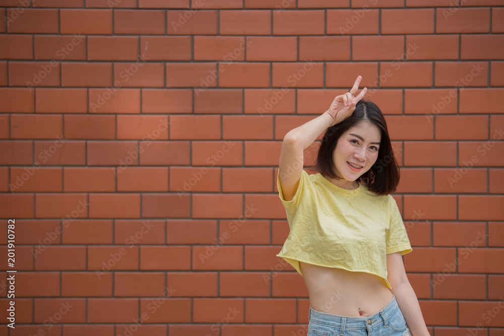 Portrait of beautiful asian chic girl pose for take a picture on brick wall,Lifestyle of teen thailand people,Modern woman happy concept Portrait of beautiful asian chic girl pose for take a picture on brick wall,Lifestyle of teen thailand people,Modern woman happy concept
