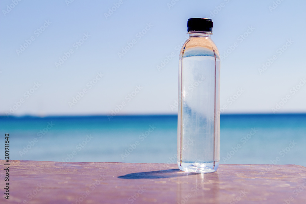 a bottle of water on a table on the beach on a sunny day a symbol of proper nutrition