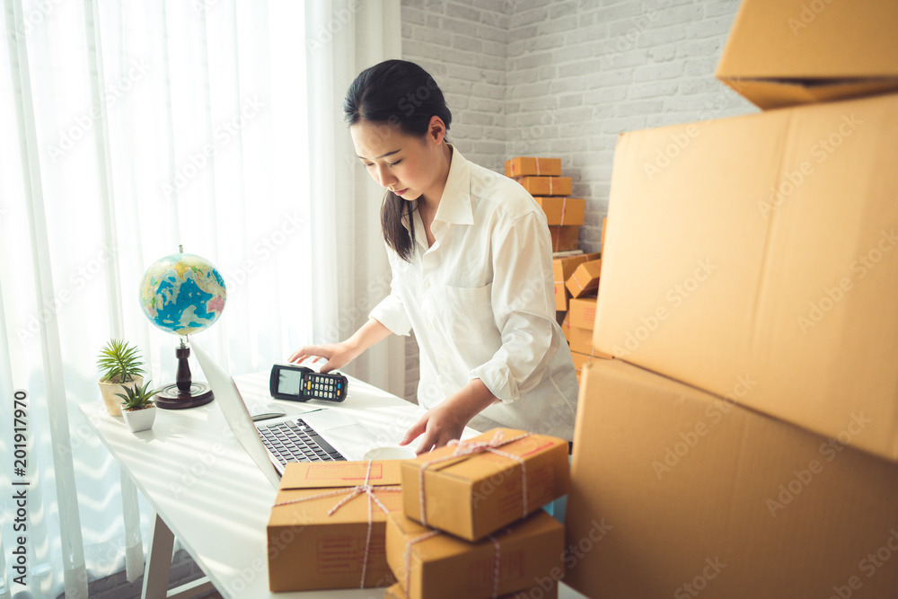Beautiful Young Asian Woman Working at home, Young Owner Woman Start up for Business Online, SME, Delivery Project, Woman with Online Business or SME Concept. Beautiful Young Asian Woman Working at home, Young Owner Woman Start up for Business Online, SME, Delivery Project, Woman with Online Business or SME Concept.