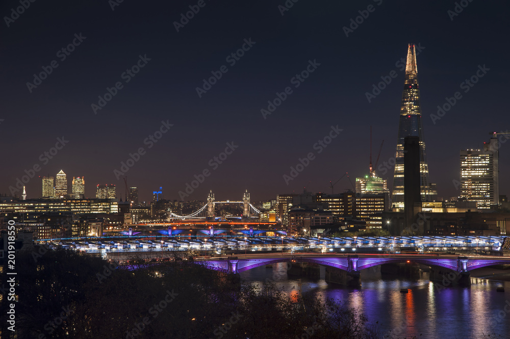 Beautiful landscape image of the London skyline at night looking along the River Thames