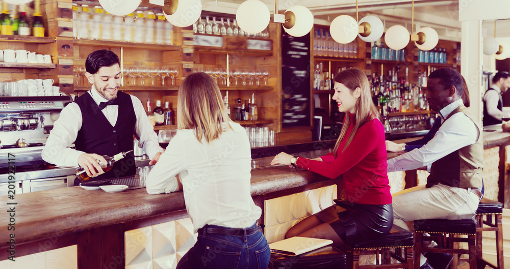 Adult girl and man are relaxing near bar counter