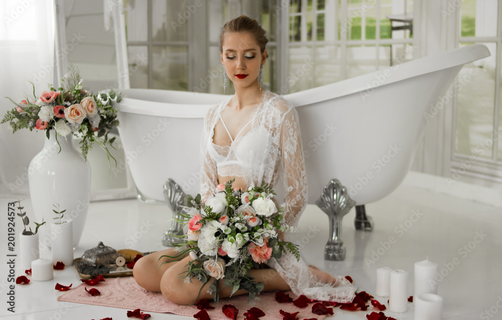 A girl is preparing a bath with rose petals. Girl with a bouquet next to a sweeping bath.
