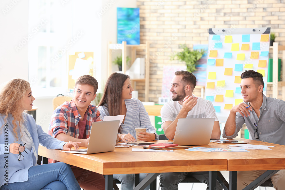 Team of young business professionals having meeting in office Team of young business professionals having meeting in office