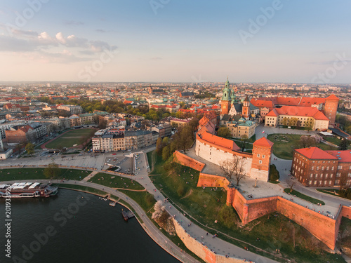 Aerial view at gold spring sunset time of royal Castle in Cracow city center, Vistula river. Krakow, Poland