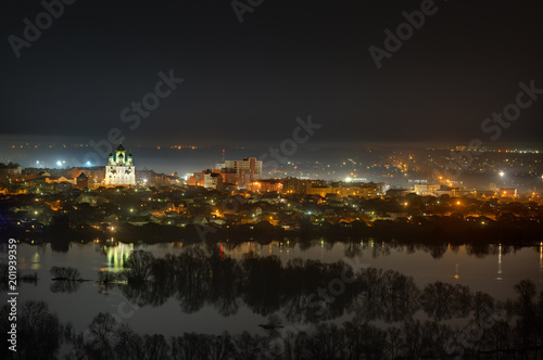 Night cityscape photographed from above. River flood in the spring.