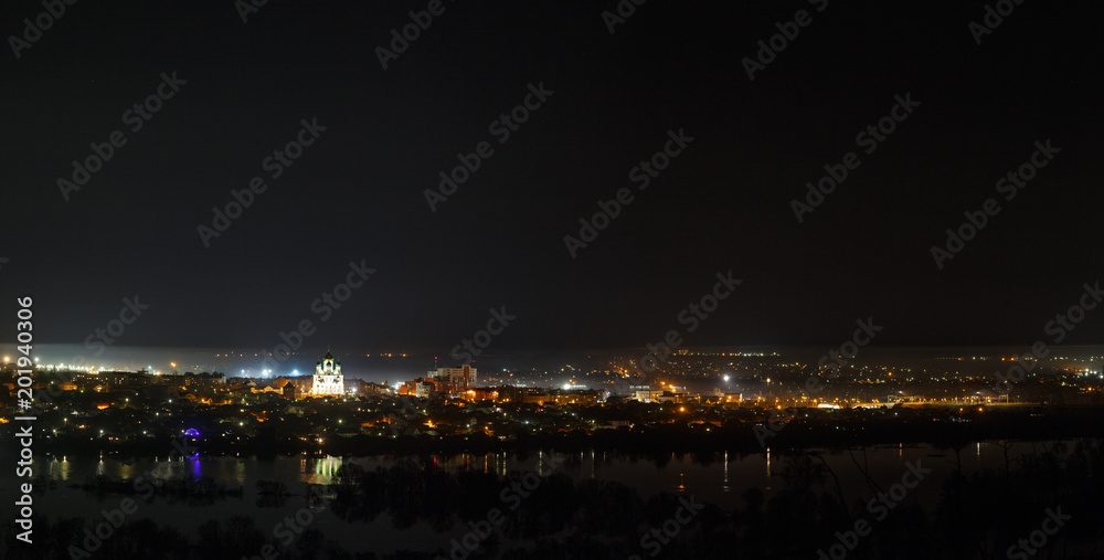 Night cityscape photographed from above. River flood in the spring. Panoramic view of the starry space.