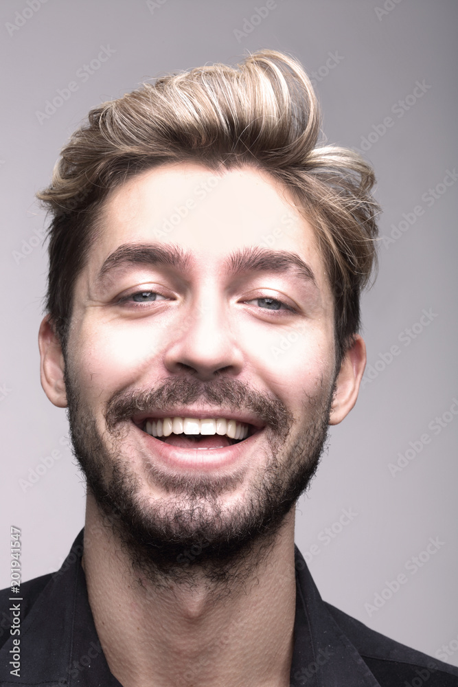 Close up portrait of smiling man on a gray background Close up portrait of smiling man on a gray background