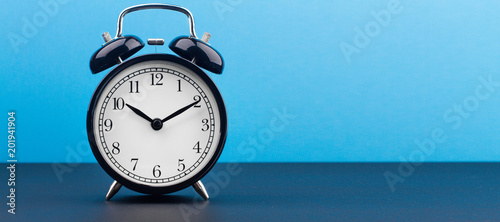 alarm clock on a color background on a wooden board
