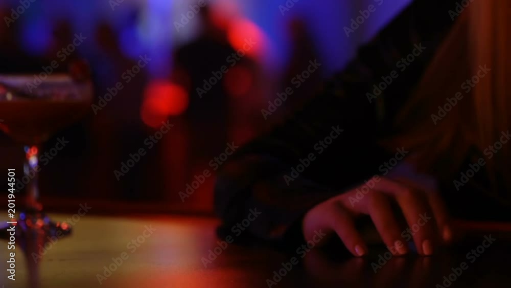 Female student sitting alone at bar with cocktail glass, luxury night club Female student sitting alone at bar with cocktail glass, luxury night club