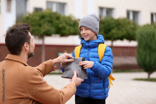 Young man giving lunch bag ...